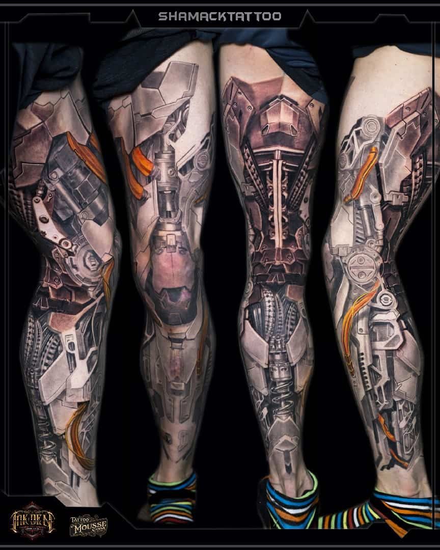 Four tattooed legs displayed side by side, showing detailed black and gray leg sleeve designs with orange accents.